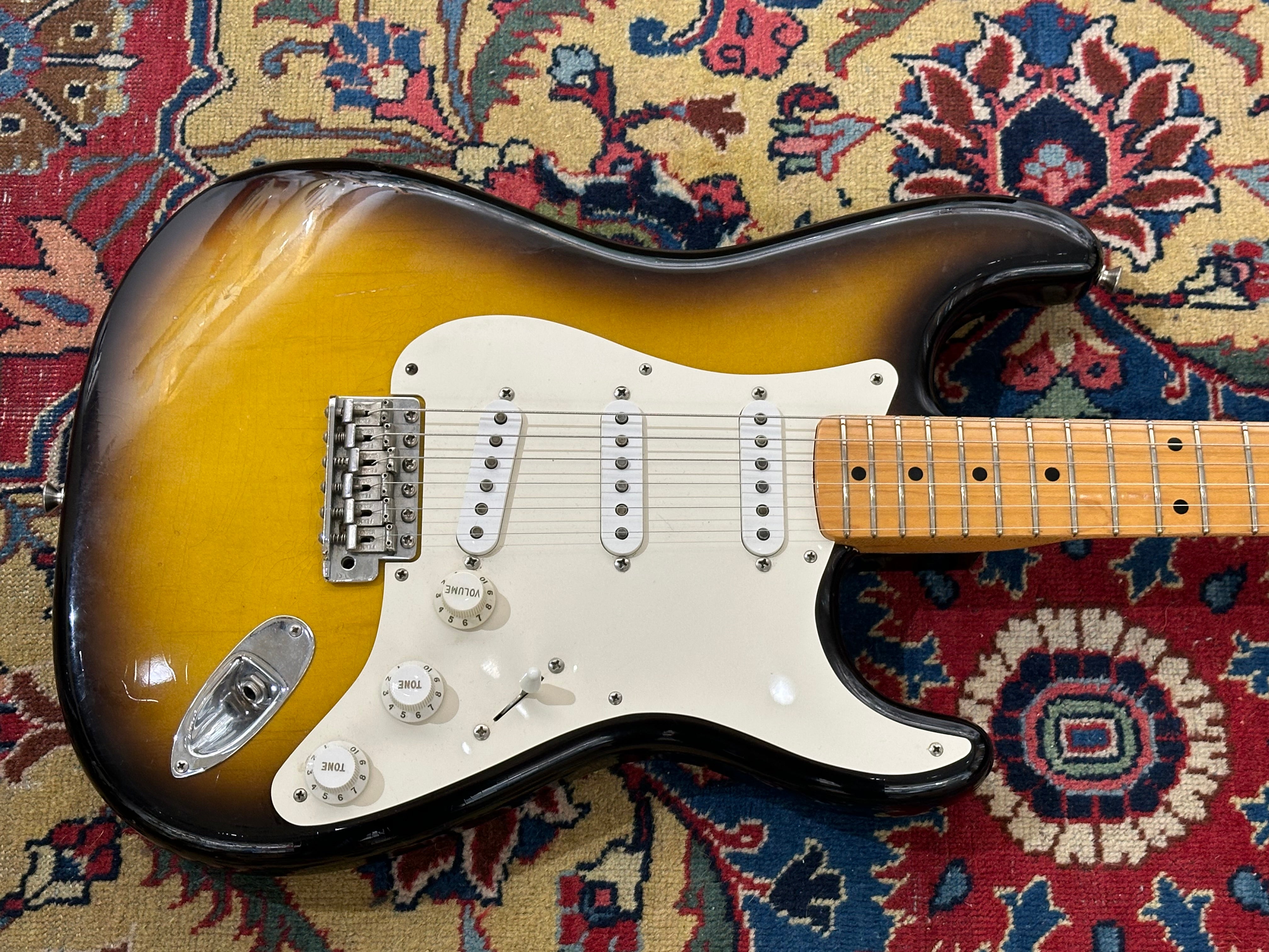 Fender Stratocaster guitar on a patterned rug