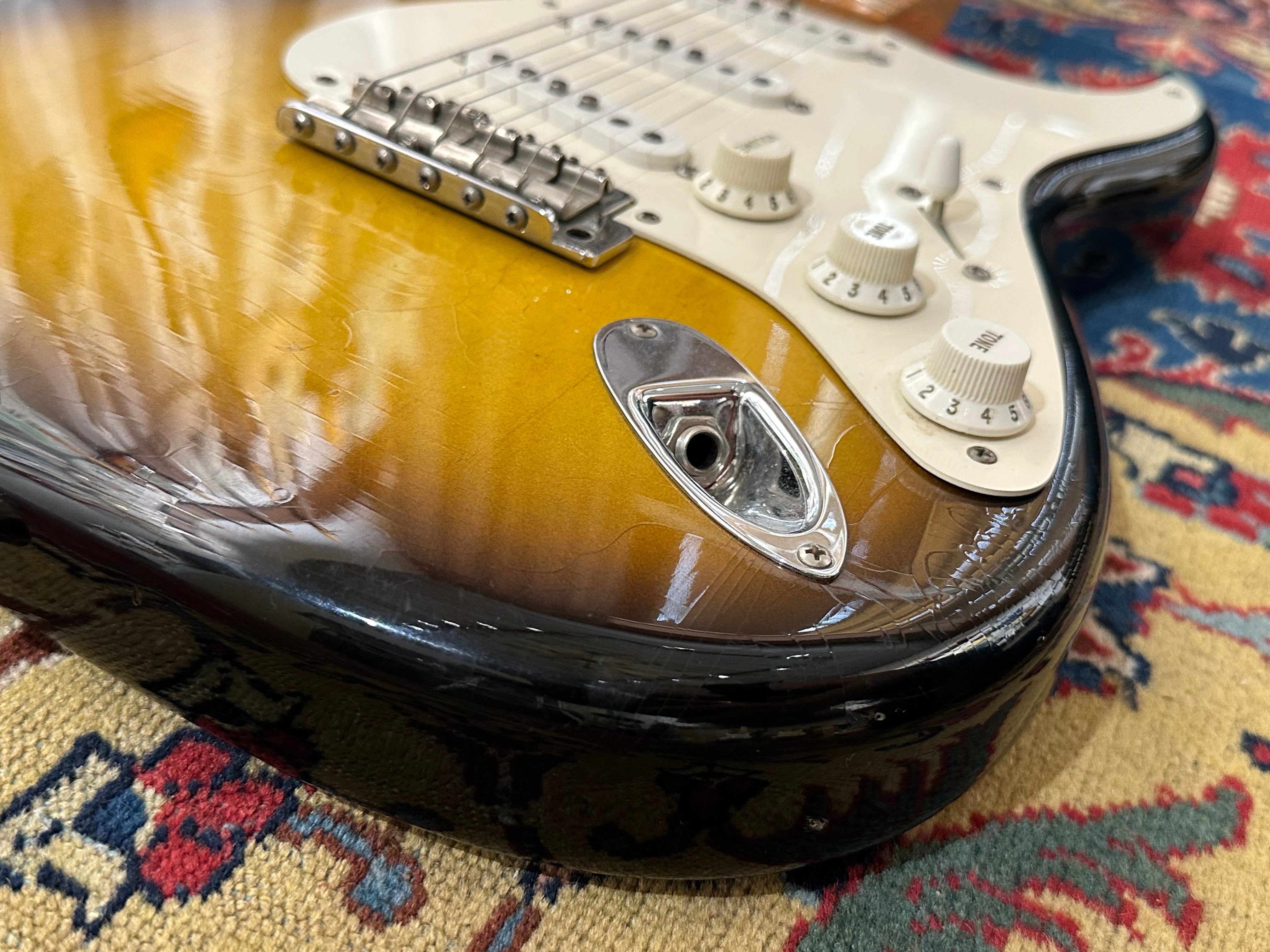 Close-up of a guitar on a patterned rug
