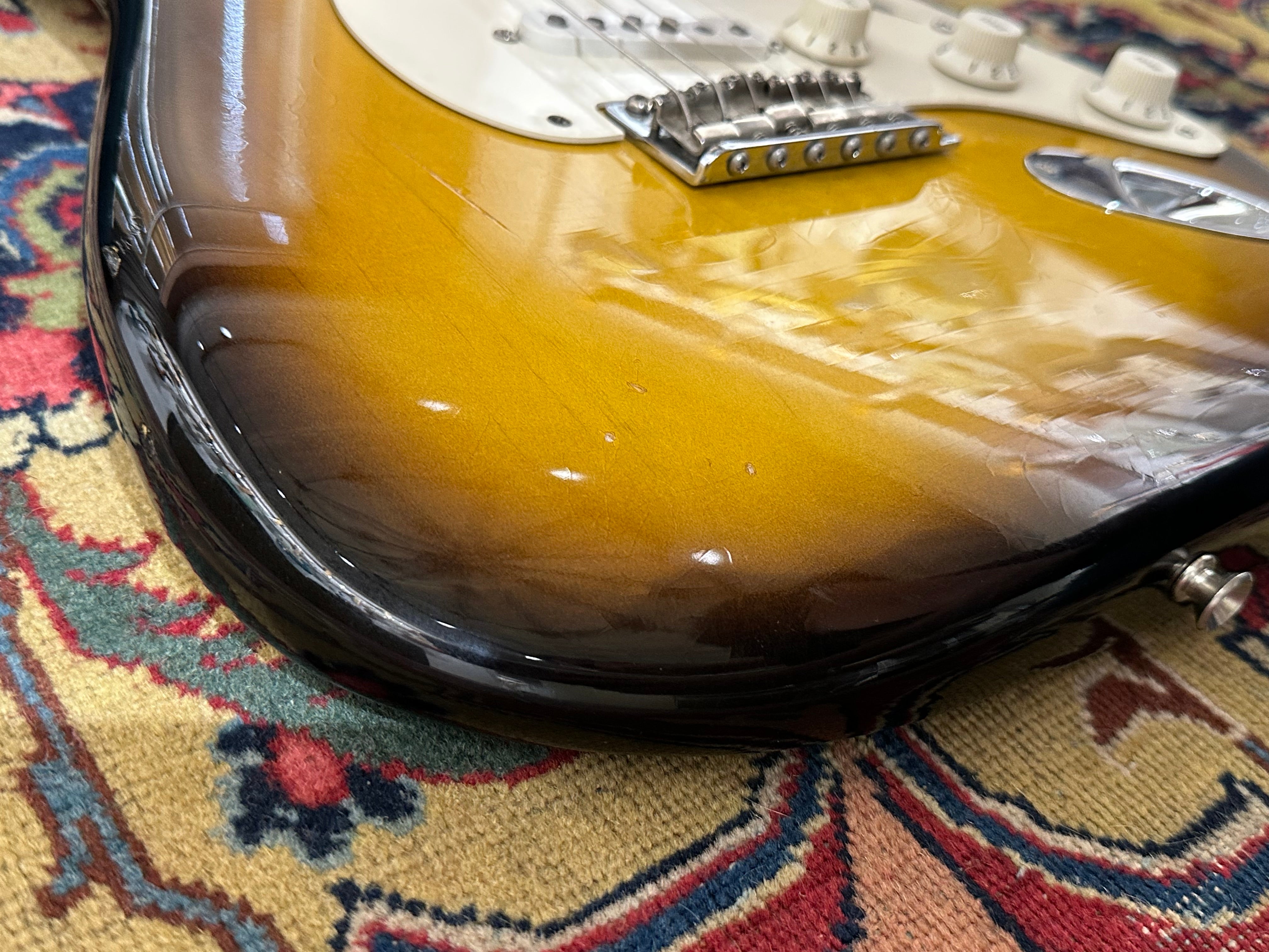 Close-up of a guitar on a patterned rug